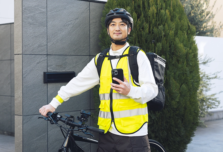 Man next to his bike holding a phone